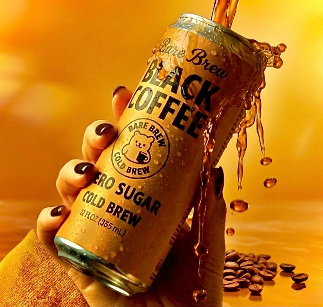 Hand holding a can of Bare Brew Black Coffee with coffee beans on a warm background
